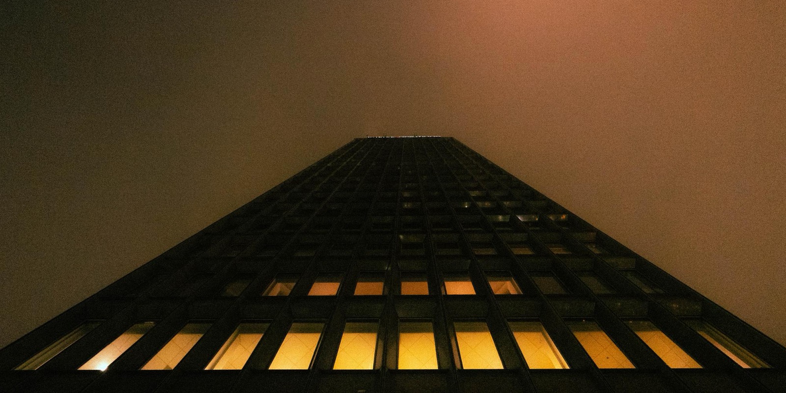 A tower rising into an orange night sky